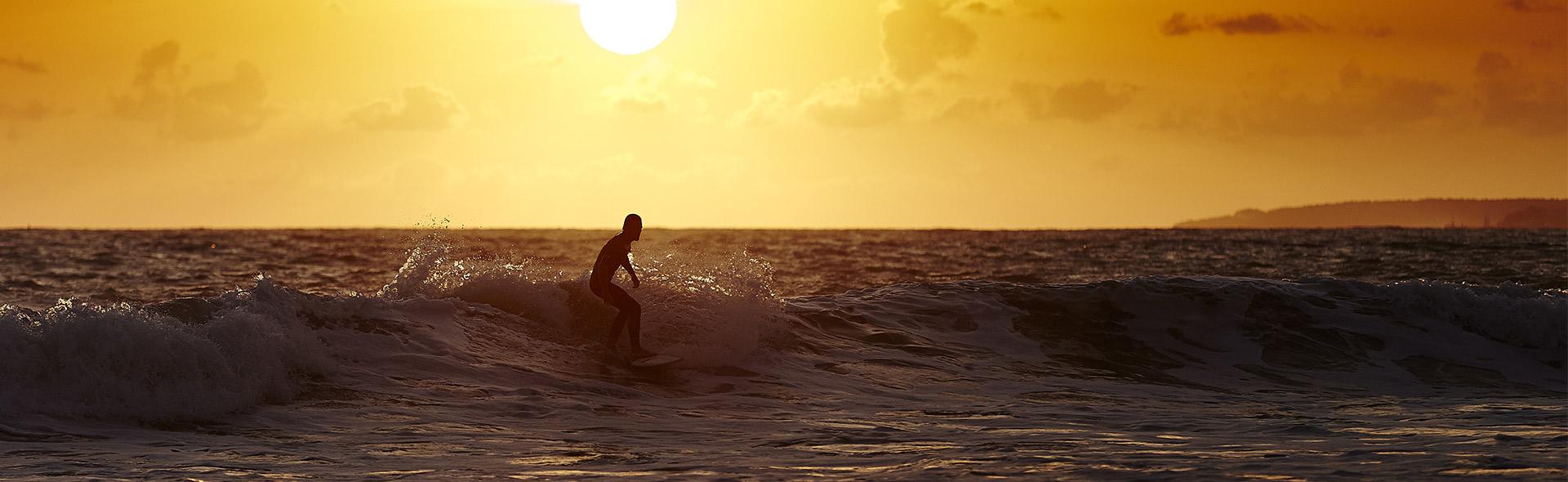 Surfeur pendant un coucher de soleil en Vendée Surfeur pendant un coucher de soleil en Vendée